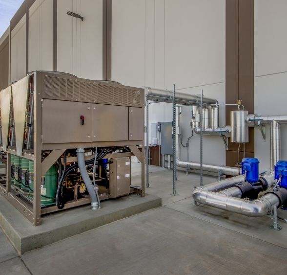 A sophisticated outdoor HVAC installation setup by Mechair Engineering Solutions, featuring a large air conditioning unit, pipework, and additional equipment, illustrating the company's expertise in comprehensive building services